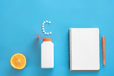 Flat lay, pills on blue background, vitamin c concept. Stock-Fotos