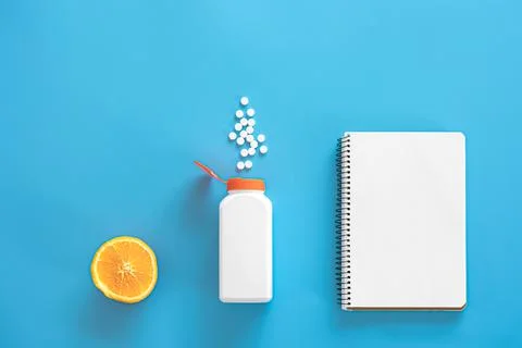 Flat lay, pills on blue background, vitamin c concept. Stock Photos