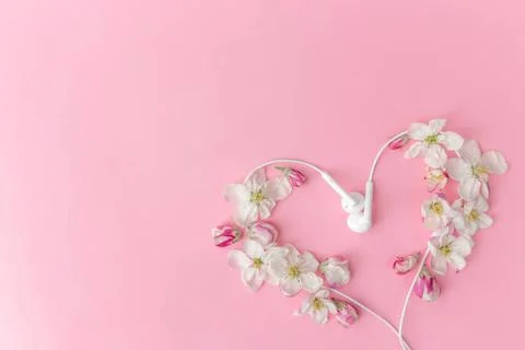  Flat lay on pink background with apple blossom heart shape and earphones ... 写真素材