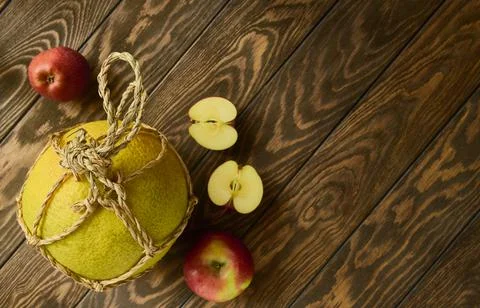 Flat lay, pomelo fruit in rope packaging and red apples on wooden table, top Stock Photos