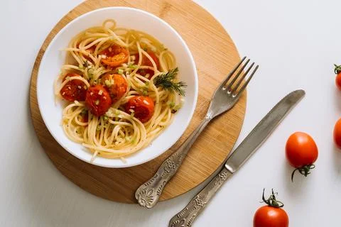 Flat lay portion of spaghetti pasta with cherry tomatoes sprinkled with spices Stockfoto's