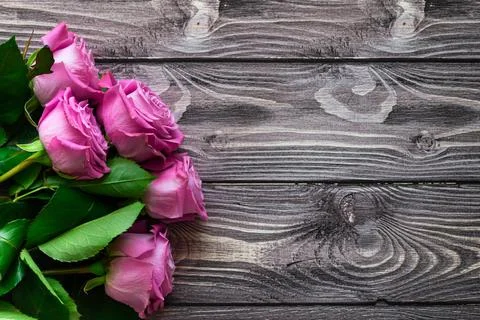 Flat lay postcard with place for your text. Bouquet of pink roses on a wooden Stock Photos