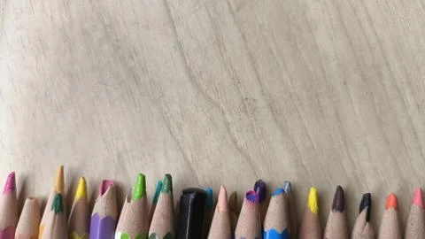 Flat lay of rainbow colored pencils on brown wooden background. Copy space .. Stock-Fotos