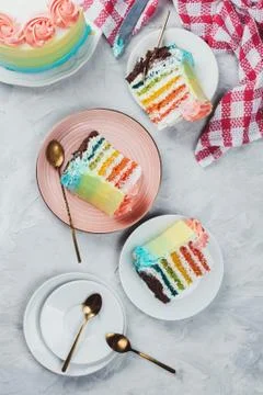 Flat lay of rainbow vegan cake pieces on grey background Stock Photos
