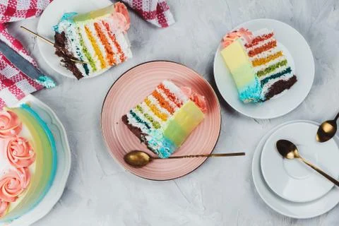 Flat lay of rainbow vegan cake pieces on grey background Stock Photos