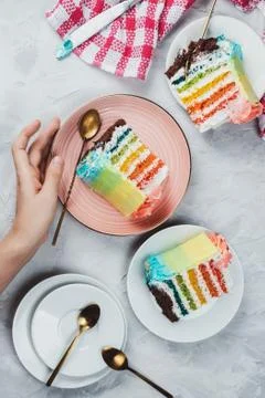 Flat lay of rainbow vegan cake pieces on grey background Stock Photos
