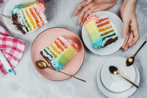 Flat lay of rainbow vegan cake pieces on grey background Stock Photos