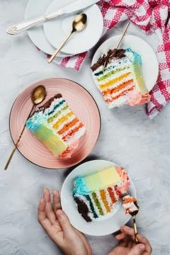 Flat lay of rainbow vegan cake pieces on grey background Stock Photos