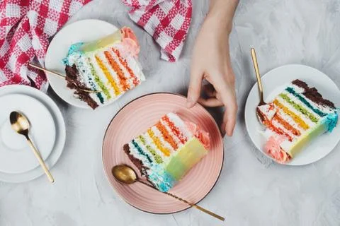 Flat lay of rainbow vegan cake pieces on grey background Stock Photos