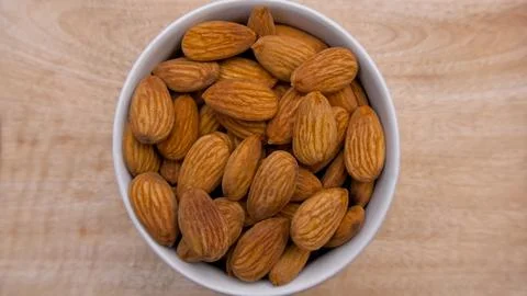 Flat Lay of Raw Almonds in a Vibrant Yellow Bowl for Healthy Living and Food Stock Photos