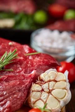 Flat lay of raw beefsteak with vegetables, herbs and spicies on metal tray Stock Photos