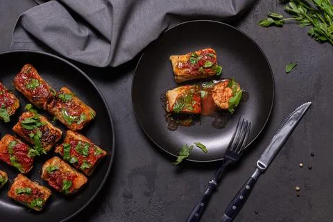 Flat lay with ready to eat stuffed cabbage rolls on black background Stock Photos