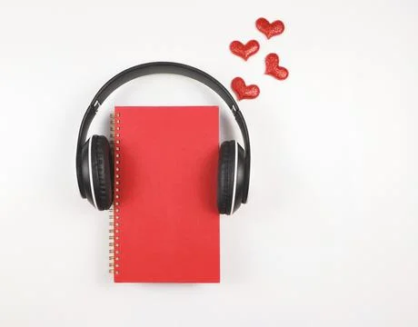 Flat lay of red notebook covered with headphones on white  background decor.. Stock Photos