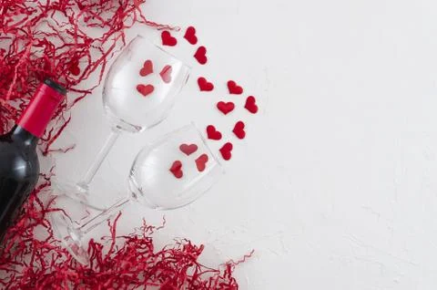 Flat lay romantic concept glasses and bottle of red wine on white background Stock Photos