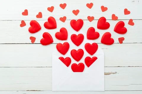 Flat lay romantic mail white envelope with different size red hearts carved in Stock Photos