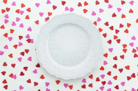 Flat lay romantic table with red hearts and empty ceramic dish for Valentines Stock Photos