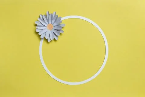 Flat lay of round card frame with color paper flower design on pastel yellow Stock Photos