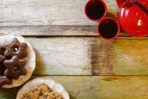 Flat lay of rustic wooden table with chocolate chip cookies in ceramic plates Stock Photos