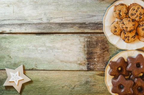 Flat lay of rustic wooden table with chocolate chip and star-shaped cookies in Stock Photos