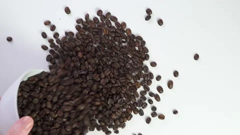 Flat lay scattering coffee beans on a brown table. Isolate ingredients for Video stock 169558353