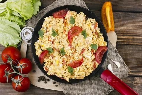 Flat lay scrambled eggs with tomatoes Stock Photos