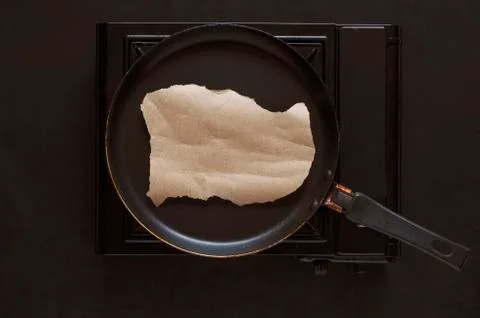 Flat lay scrap of clean brown paper in a frying pan. Stock Photos