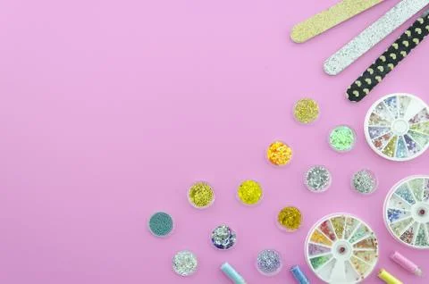 Flat lay sequins with nail polish buff on a pink workpspace with copy space on Stock Photos