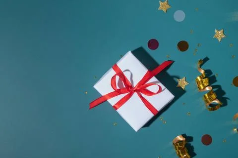 Flat lay shiny holiday background with gift box, stars, streamers, sparkles Stock Photos