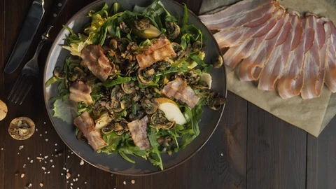 Flat lay shot: chef adds roasted slice of bacon to the vegetable salad with meat Stock Footage 114182960
