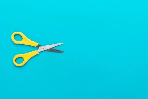 Flat lay shot of opened yellow scissors with copy space Stock Photos