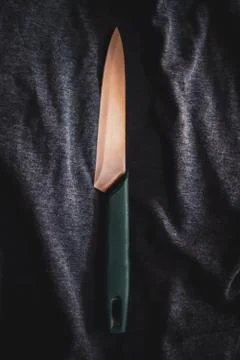 Flat lay of single kitchen knife on black cloth background. Фото