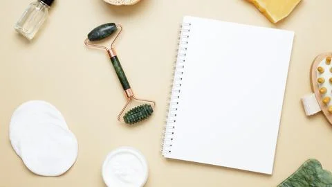 Flat lay of skincare essentials with notebook mockup including marble face ro Stock-Fotos