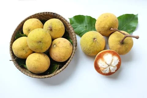 Flat lay  sliced santol fruit in a Wicker basket isolate on white background Stock Photos