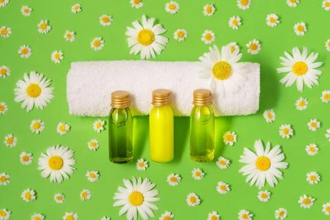 Flat lay of small mockup bottles with spa cosmetic products on green background Stock Photos
