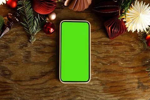 Flat Lay Smartphone with Green Screen Mockup on Wooden Table. festive mobil.. Stock Photos