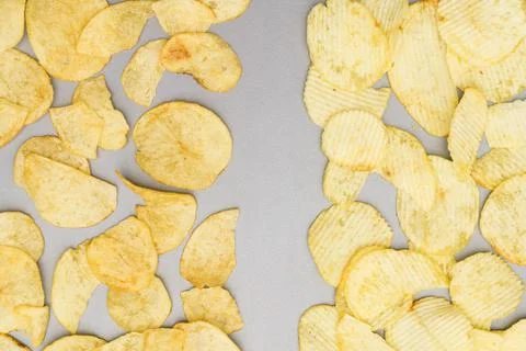 Flat lay of snack, Arrangement of crispy potato chips on gray background Photos