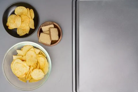 Flat lay of snack, Crispy potato chip and wafer in various containers with pl Stock Photos