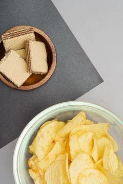 Flat lay of snack, Crispy potato chip in glass bowl and wafer in wood bowl ov Foto stock