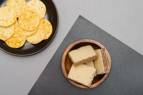 Flat lay of snack, Crispy potato chip in glass bowl and wafer in wooden bowls Stock Photos