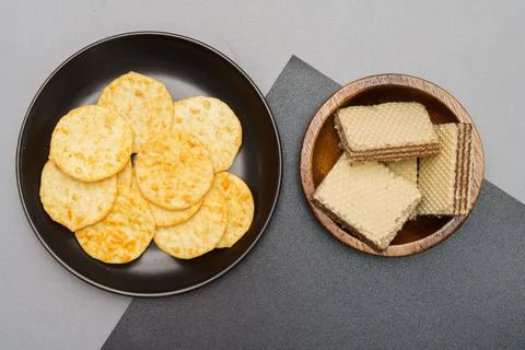Flat lay of snack, Crispy potato chip in glass bowl and wafer in wooden bowls Stock Photos