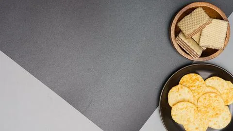 Flat lay of snack, Crispy potato chip and wafer in various containers on gray Stock Photos