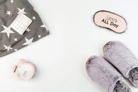 Flat lay with Soft fluffy slippers gray color, pillow, blindfold, pills and p Stock-Fotos