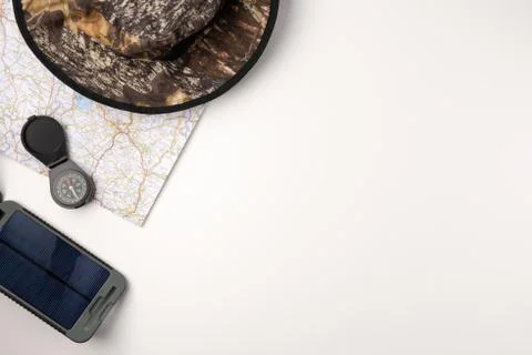 Flat lay solar battery, compas and traveler accessories on white background.  Stock Photos