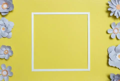 Flat lay of square card frame with color paper flowers Stock Photos