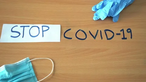 Flat lay of "STOP COVID-19" text with a face mask and gloves. Stock Footage 134553966