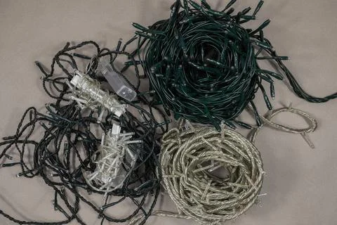 Flat lay string Christmas lights storage. Neatly wrapped up garlands on beige Stock Photos