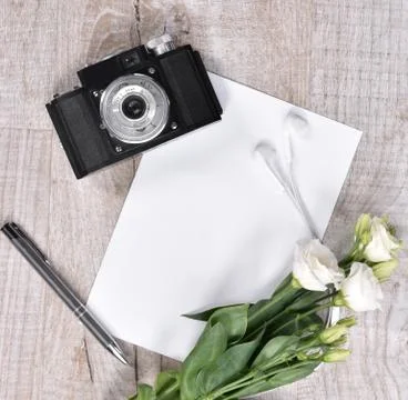 Flat lay style with camera, roses, notebook, earphones and pen Stock Photos