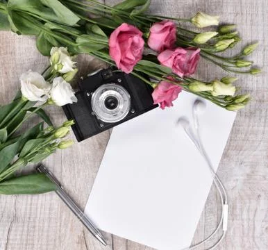 Flat lay style with camera, roses, notebook, earphones and pen 写真素材