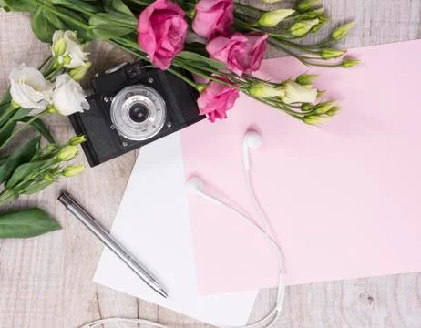 Flat lay style with camera, roses, notebook, earphones and pen Stock-Fotos