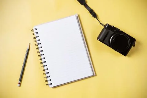 Flat lay style of empty book and pencil and retro camera with yellow pastel b Stock Photos